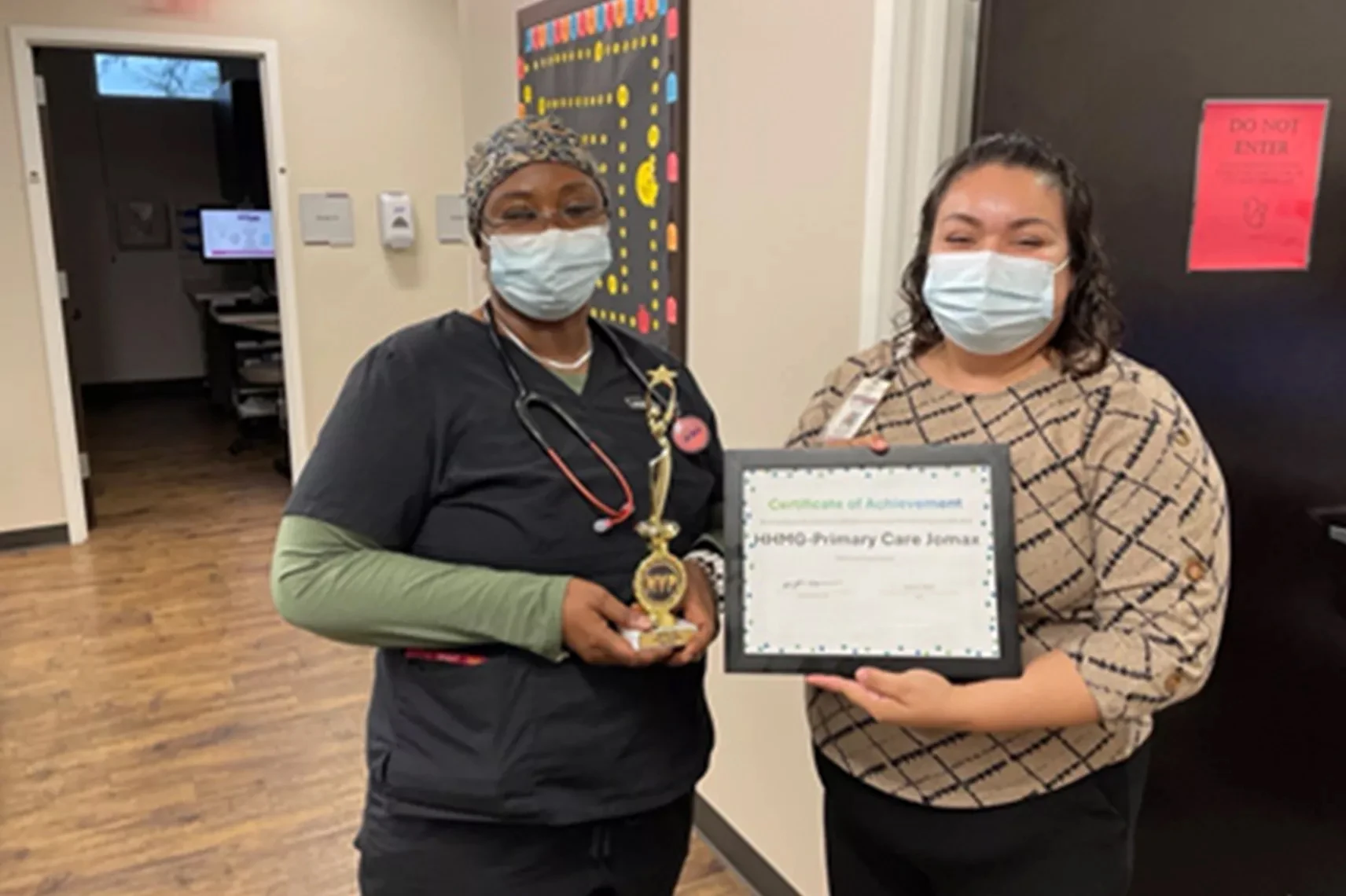 Honor Health Jomax Primary Care Employees pose with a trophy and certificate